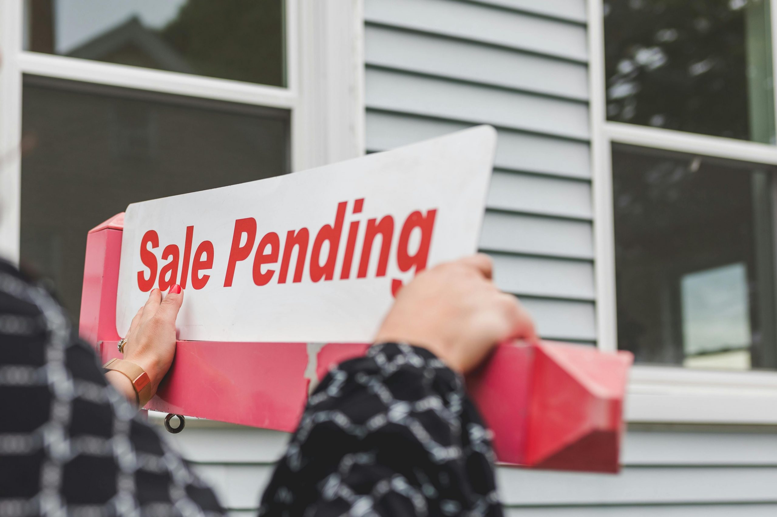 Real estate agent putting up a sale pending sign after learning how sell more houses from Century 21 Realty Services in Camp Hill PA